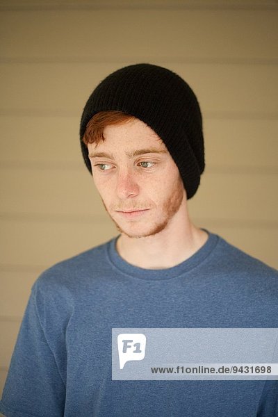Portrait of teenage boy in beanie hat looking sideways
