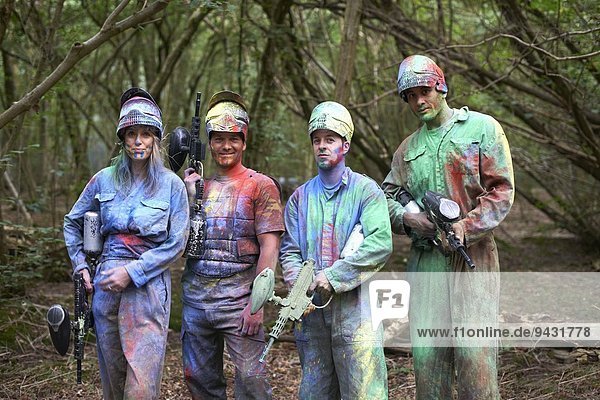 Paintball players in paintball wear marked with paint