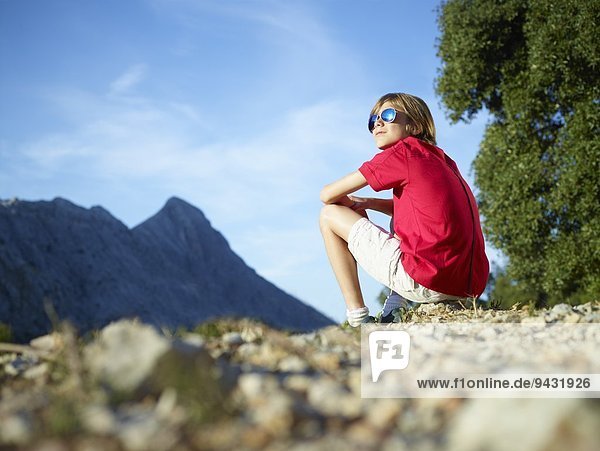 Junge sitzend mit Blick auf die Berge  Mallorca  Spanien