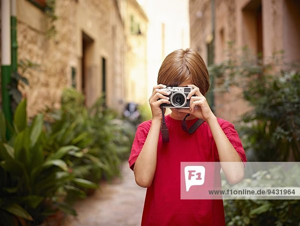 Junge fotografiert in der Straße mit Spiegelreflexkamera  Mallorca  Spanien