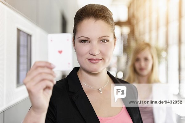 Businesswoman holding up Ace of Hearts card