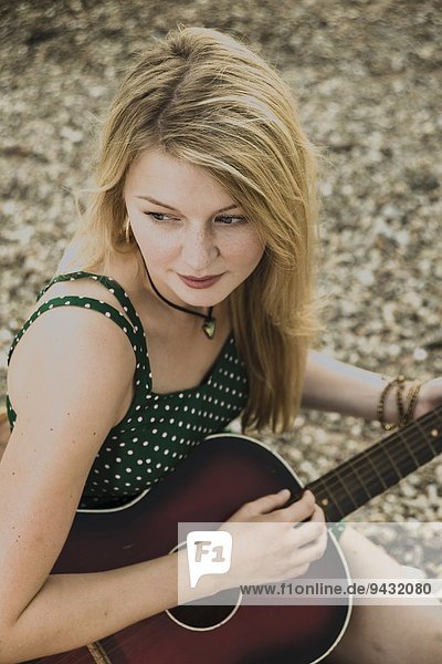 Young woman playing guitar  high angle