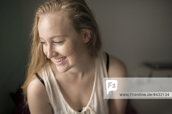 Porträt einer jungen Frau mit Sommersprossen lachend