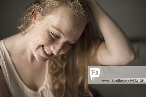 Porträt einer jungen Frau mit Sommersprossen lachend