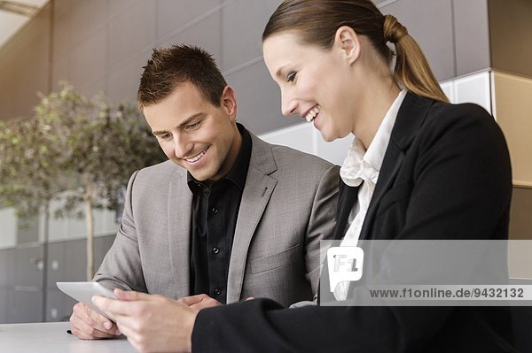 Businesswoman and businessman using digital tablet for discussion