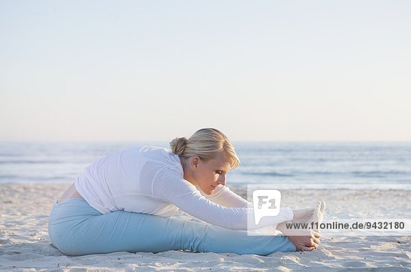 Frau beim Yoga-Gebet am Strand
