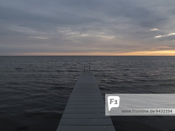 Pier,  Meer und Sonnenaufgang über dem Horizont