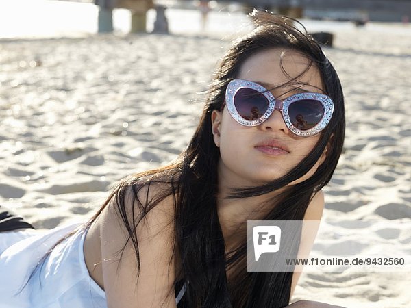 Portrait of young woman on beach in funky sunglasses  Port Melbourne  Melbourne  Victoria  Australia