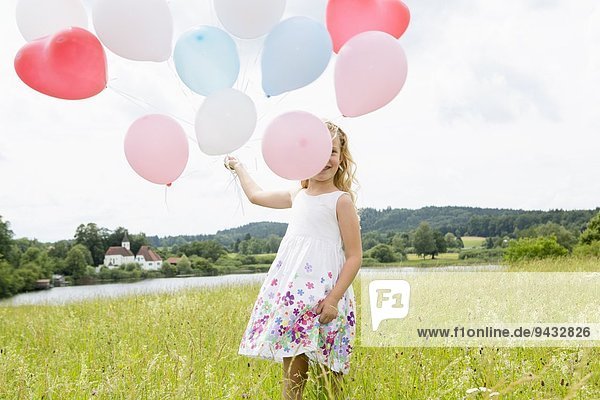 Mädchen mit Luftballons im Feld