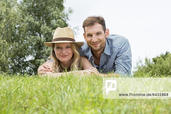 Mid adult couple lying on grass  portrait
