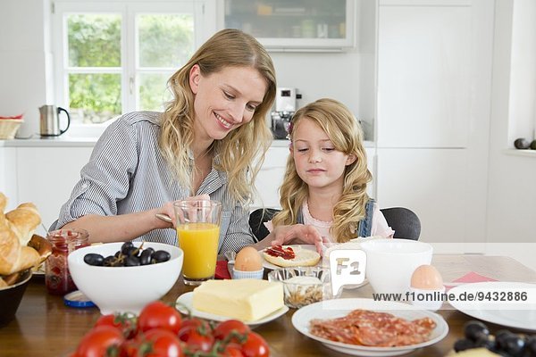 Mother and daughter eating at kitchen table