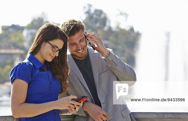 Businessman and woman using smartphone