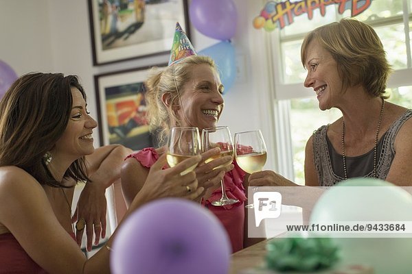 Three mature women toasting with wine glasses
