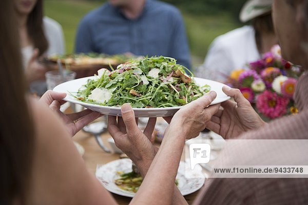 Group of adults enjoying meal  outdoors