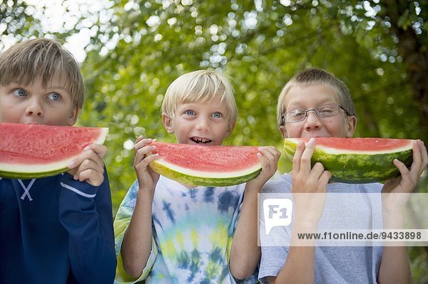 Freunde essen Wassermelone im Garten