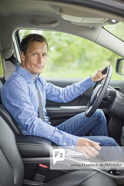 Porträt eines selbstbewussten Mannes im Auto sitzend