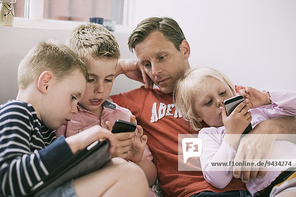 Father and children using technologies at home