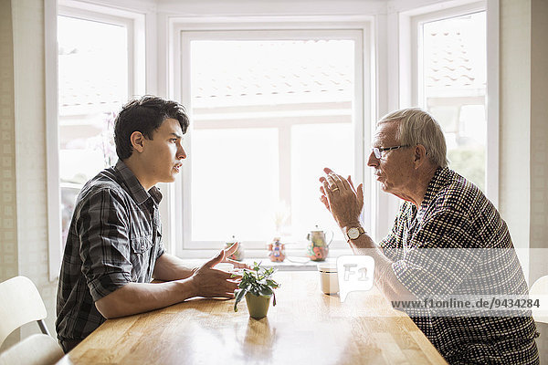 Seitenansicht des Großvaters und des Enkels beim Kaffeetrinken