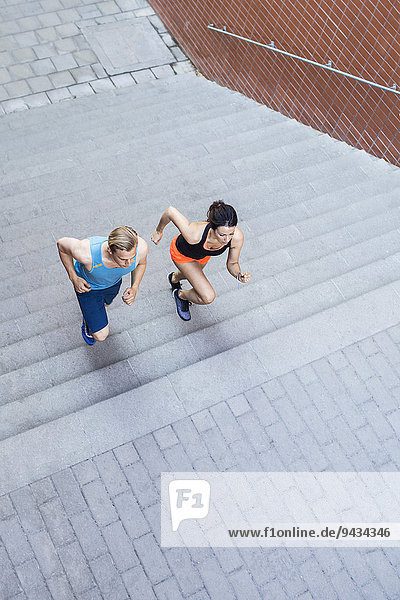 Hochwinkelansicht des auf einer Treppe im Freien laufenden Paares