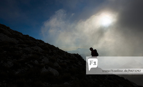 Silhouette of a hiker on the mountain ridge at sunrise  mount Strega  Apennines  Marche  Italy  Europe
