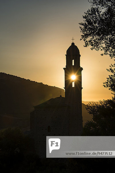 Sonne scheint durch Glockenturm  Silhouette eines Kirchturms  Abendstimmung  Sonnenuntergang  Haute-Corse  Korsika  Frankreich  Europa