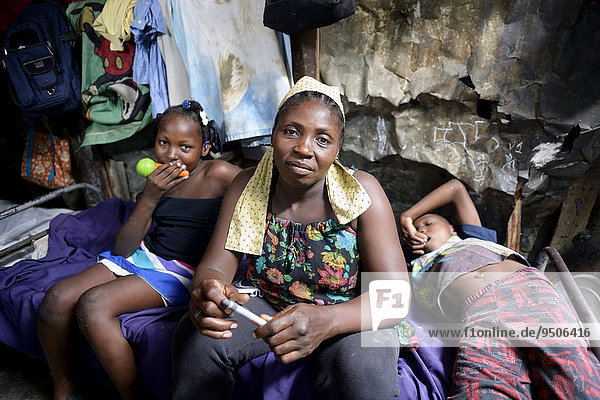 Frau  40 Jahre  und zwei Kinder  8 und 10 Jahre  in einer Baracke  Lager für Erdbebenflüchtlinge Camp Icare  5 Jahre nach dem Erdbeben 2010  Fort National  Port-au-Prince  Haiti  Nordamerika
