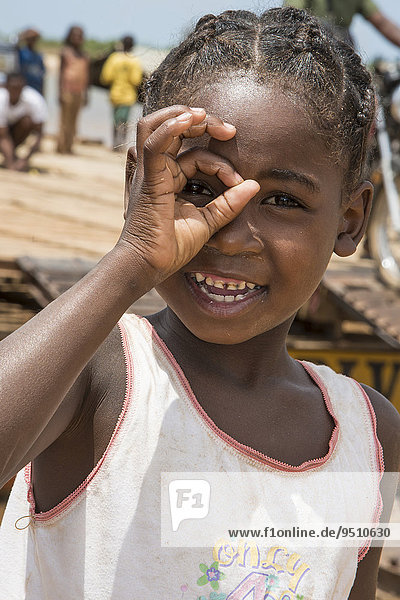 Girl  6 years  looking through her fingers  Belo-sur-Tsirihibina  Madagascar  Africa