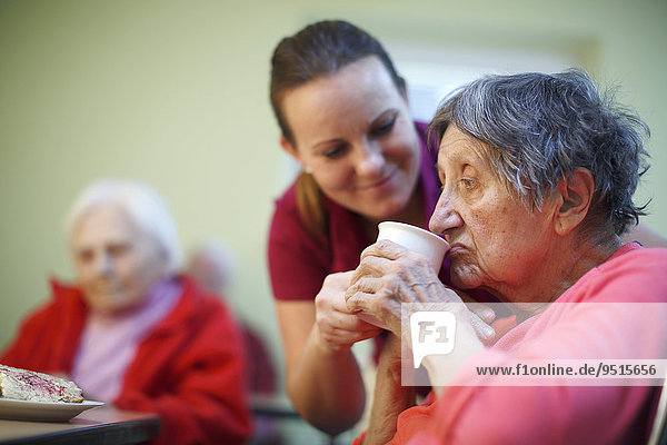 Frau  81 Jahre  im Altersheim  beim Frühstück  unterstützt durch Altenpflegerin  Kralovske Porici  Böhmen  Tschechische Republik