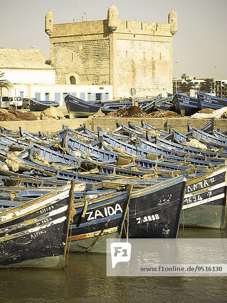 Old blue fishing boats in the port of Essaouira  behind the fortress of Essaouira  Unesco World Heritage Site  Morocco  Africa