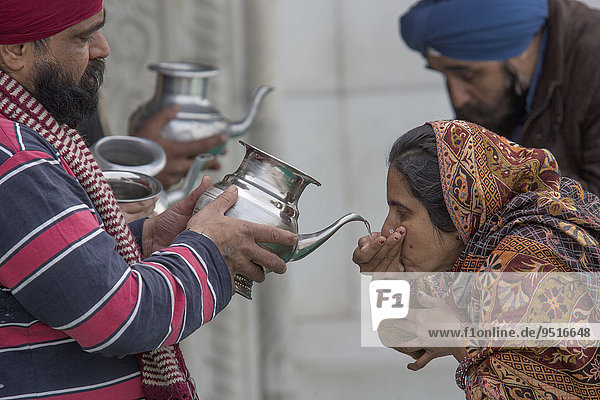 Pilgrims drinking holy water  Bangla Sahib Gurudwara  Sikh temple  Delhi  India  Asia