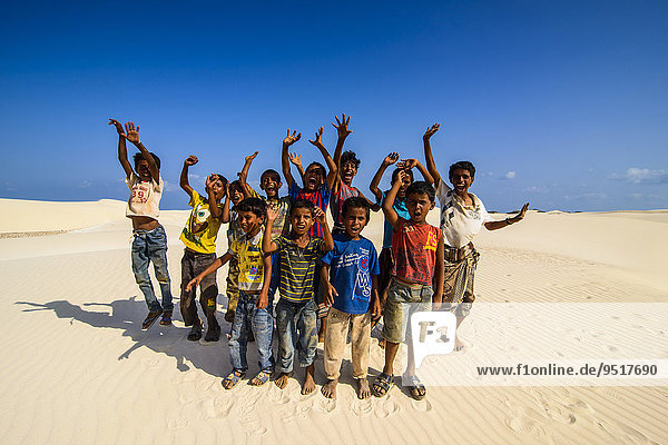 Young Socotrian boys posing in the sand dunes at the south coast of the island of Socotra  Yemen  Asia