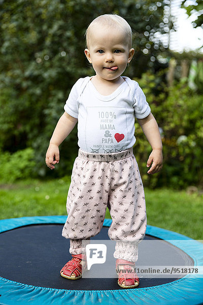 Toddler  18 months  on a trampoline in the garden