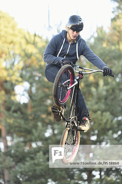 Teenager auf einem BMX-Rad springt in die Luft