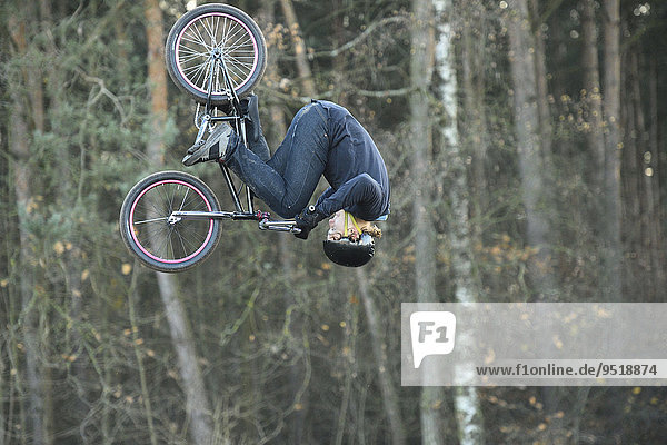 Teenager auf einem BMX-Rad springt in die Luft