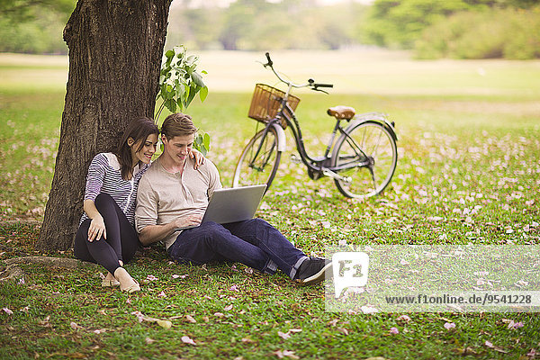 Young couple using laptop outdoor