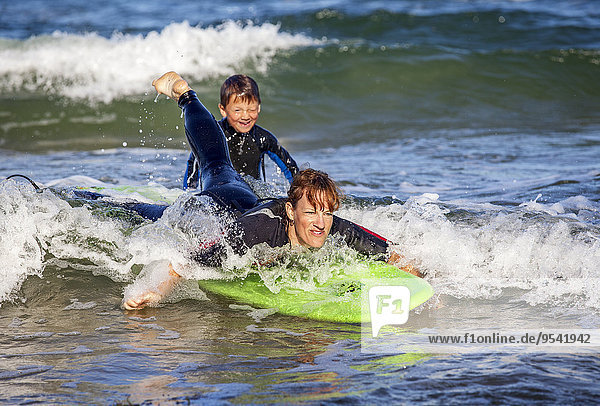 Mother with son surfing