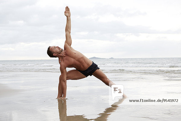 Mann Strand üben Yoga