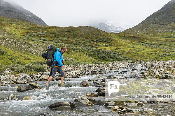 Man crossing mountain river