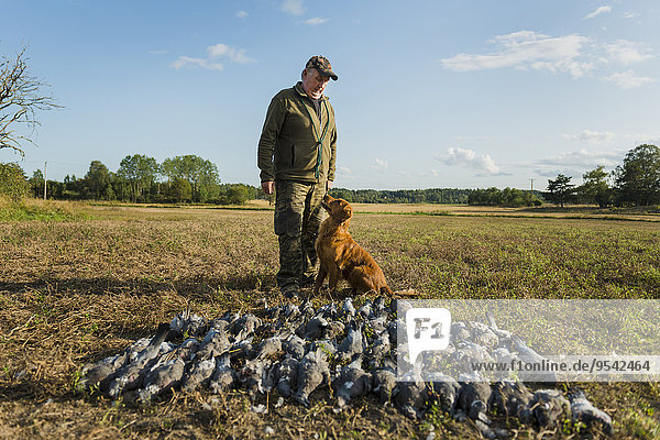 Man with hunting dog and dead birds