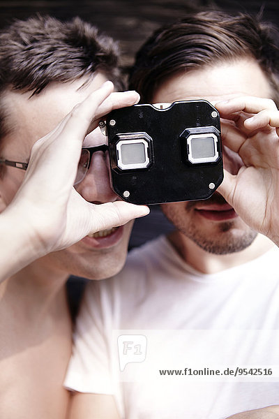 Young men looking through viewfinder