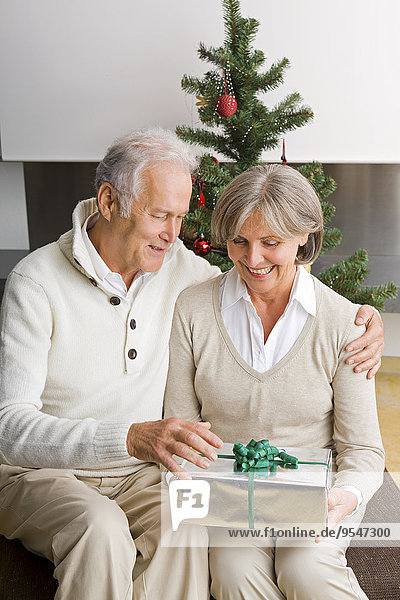 Seniorenpaar tauscht zu Hause Weihnachtsgeschenke aus