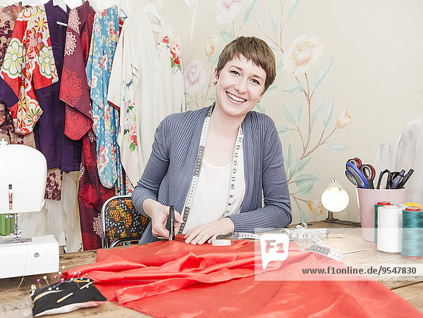 Portrait of smiling female fashion designer at her desk