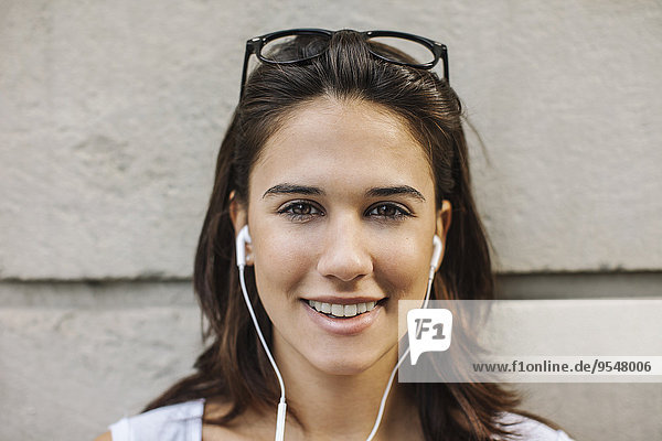 Portrait of smiling young woman with ear phones