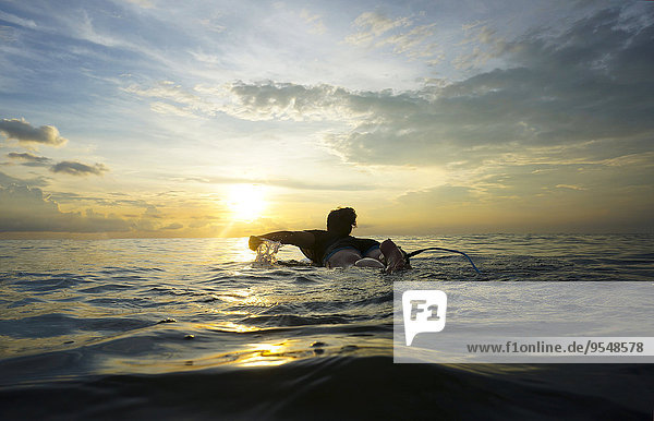 Indonesien  Bali  Canggu  junge Frau am Surfbrett bei Dämmerung