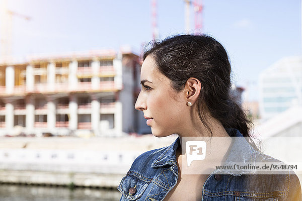 Germany  Berlin  profile of young woman in front of construction site