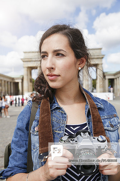 Germany  Berlin  portrait of female tourist with camera