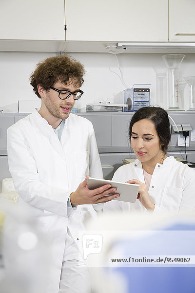 Wissenschaftler  die im Labor mit digitalen Tabletten arbeiten