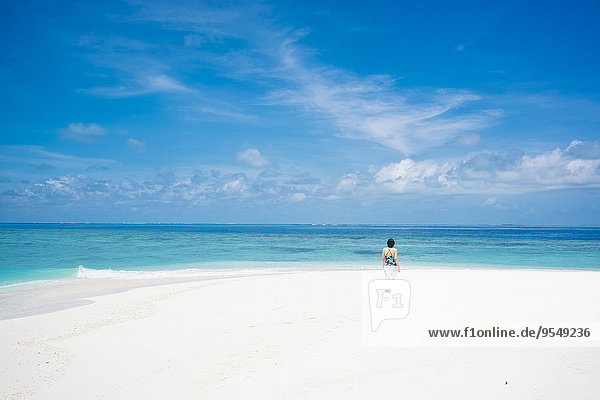 Malediven  Ari Atoll  junge Frau beim Spaziergang am Traumstrand