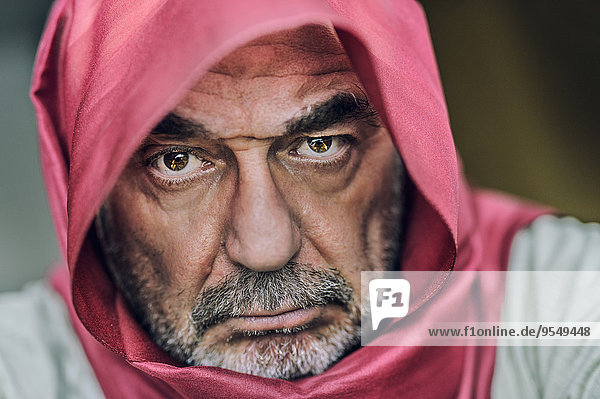 Porträt eines älteren Mannes mit Vollbart und rotem Kopftuch