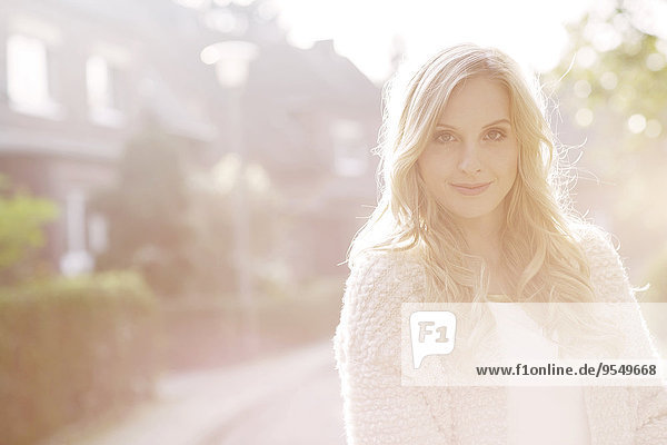 Portrait of smiling blond woman at backlight